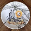 Plato de porcelana con Ilustración de una tumba y un girasol con cara de calavera en Halloween